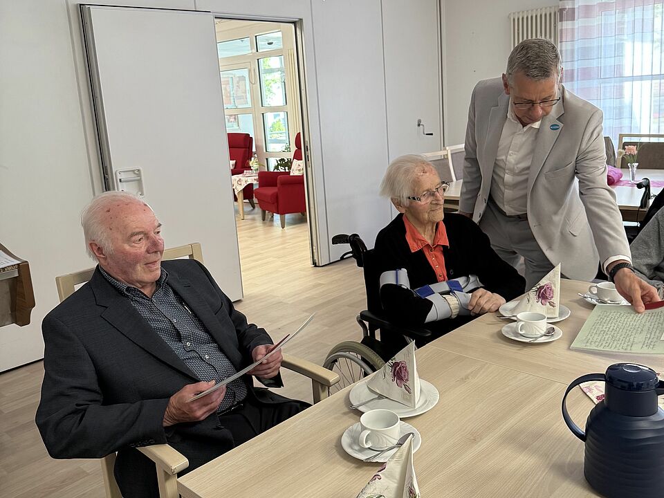 Bürgermeister Beckmann zeigt einem Gründungsmitglied ein Dokument aus der Gründungszeit des Stadtrats.