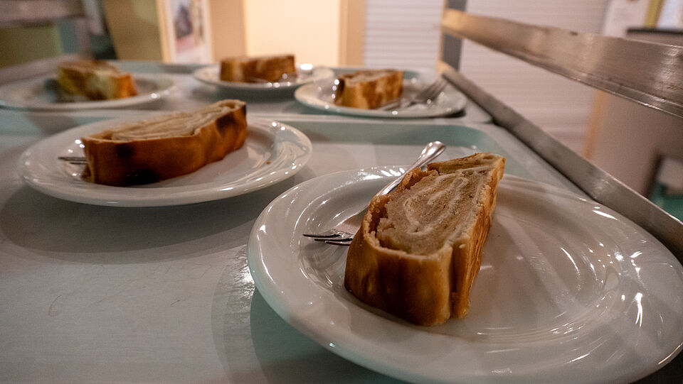 8407 Fünf gedeckte Apfelstrudel auf Tellern mit einer Gabel